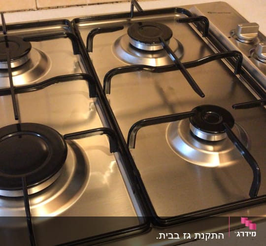 כיריים גז עם ארבעה מבערים וכפתורי שליטה